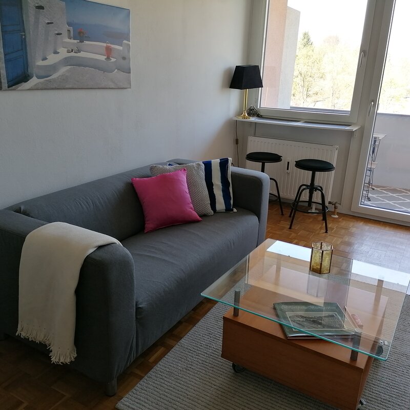 Wohnzimmer, möbliert mit Couch, Tisch, Kommode, Regal mit TV und Musikanlage, Kleiderkasten