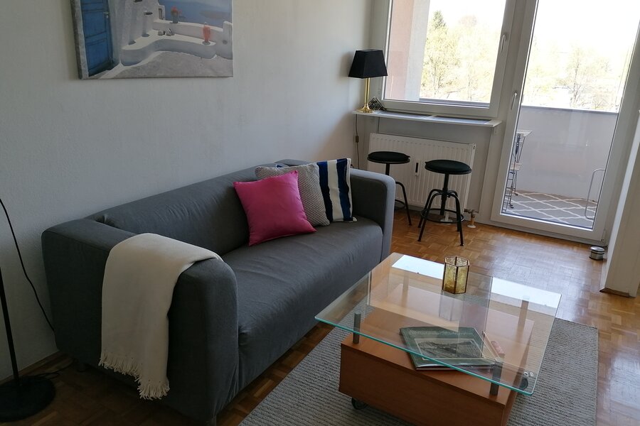 Wohnzimmer, möbliert mit Couch, Tisch, Kommode, Regal mit TV und Musikanlage, Kleiderkasten