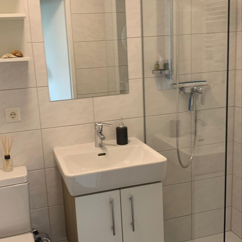 Badezimmer mit Dusche, Waschbecken, Toilette, Aufbewahrung