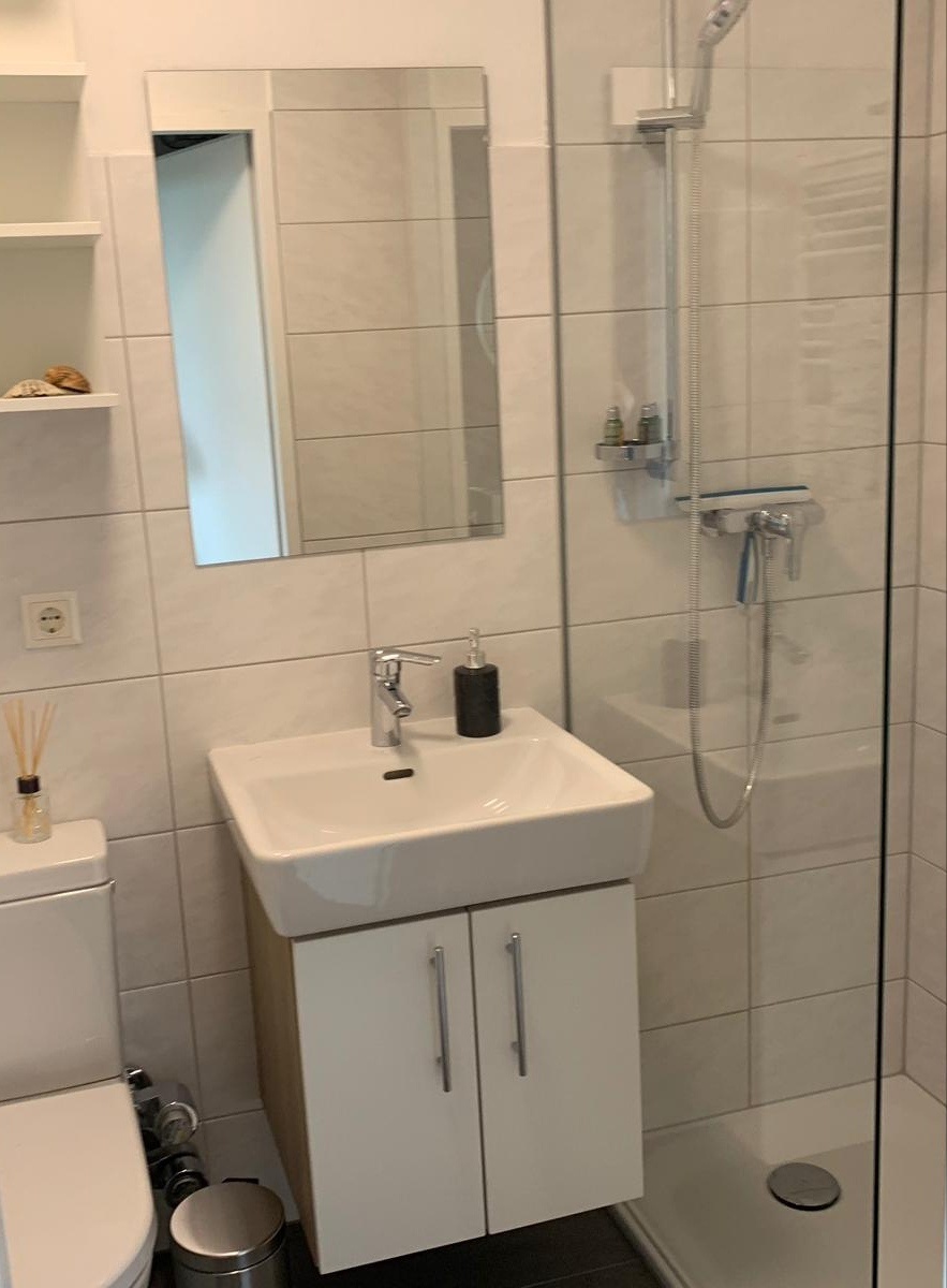 Badezimmer mit Dusche, Waschbecken, Toilette, Aufbewahrung