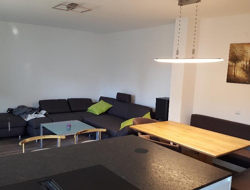 Im Wohnbereich befindet sich eine großzügige Couch und ein großer Flachbildfernseher.