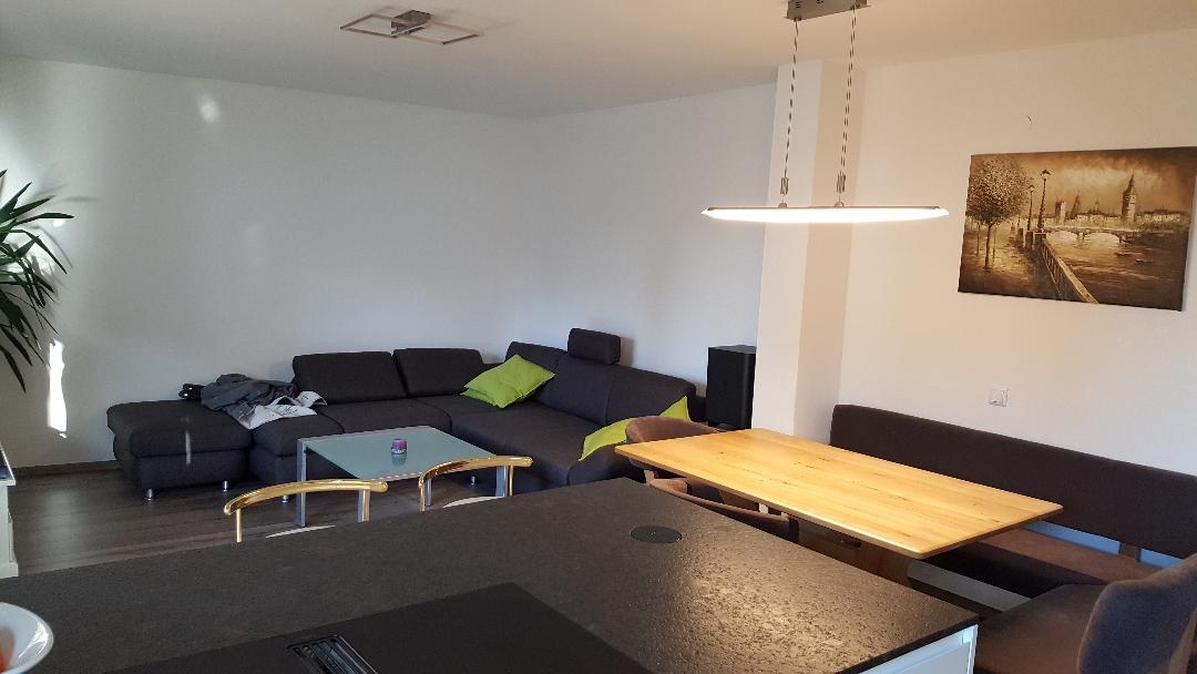 Im Wohnbereich befindet sich eine großzügige Couch und ein großer Flachbildfernseher.