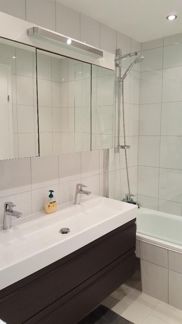 Das Badezimmer ist mi einem Doppelwachbecken und einer Badewanne ausgestattet.