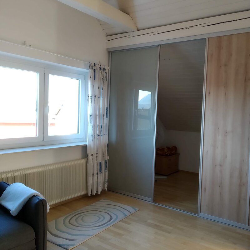 the sleeping alcove is separated from the rest of the living room by a sliding wall