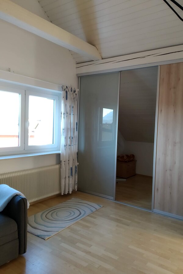 the sleeping alcove is separated from the rest of the living room by a sliding wall