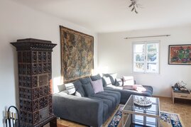 Wohnzimmer mit Kachelofen und Blick auf die Berge